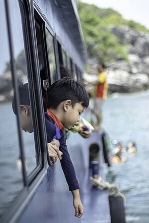 Portrait of Asia boy on the window boat in the sea.の写真素材