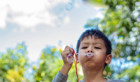 Portrait asia boy blowing bubbles  in garden.の写真素材