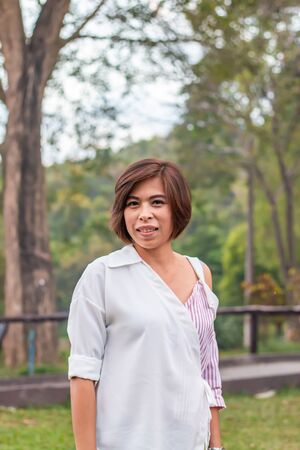 Portrait Asian woman Standing in the grass Background treeの写真素材