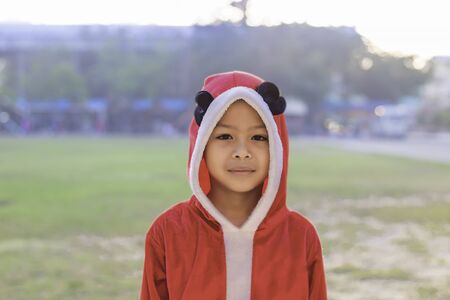 Asia boy wearing a red Christmas Background on the school lawn.の写真素材