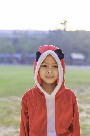 Asia boy wearing a red Christmas Background on the school lawn.の写真素材