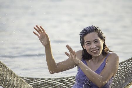 Portrait of Asian woman wearing a swimsuit on Hammock swing in sea.の写真素材