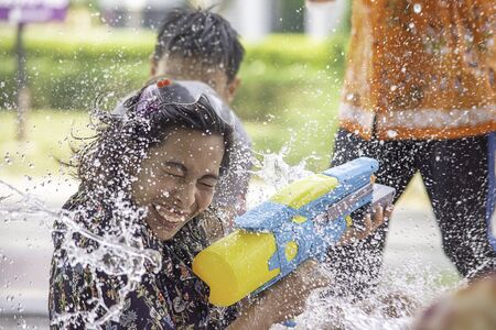 Asian woman holding a water gun play Songkran festival or Thai new year in Thailand.の写真素材