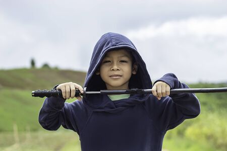 Portrait of a boy holding a wooden sword play.