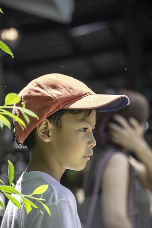 Portrait of Asian boy wearing a red cap and white  shirt is smile.の写真素材