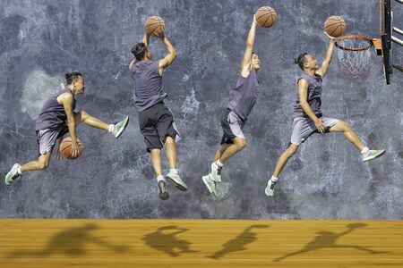 Basketball in hand man jumping Throw a basketball hoop On the wooden floor Background plaster wall loft  with The pattern of cracks.の写真素材