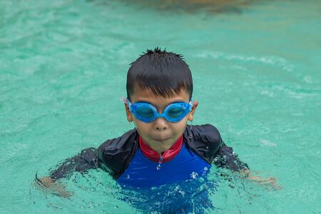 Asian boys are swimming in the pool.の写真素材