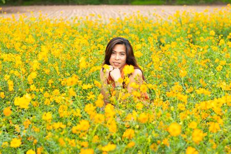 Portrait woman and Yellow flower or Cosmos sulphureus Cav.の写真素材