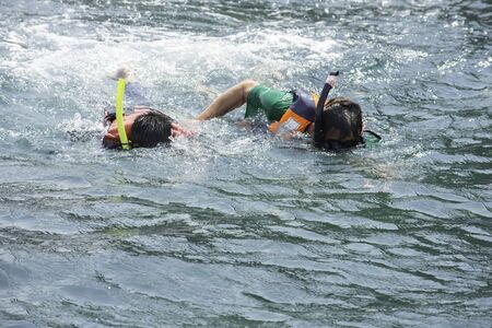 Asian man and Boy wearing a life jacket and scuba diving in the sea.の写真素材