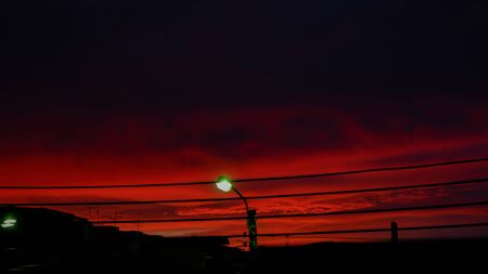 Silhouette of Street lamp illuminating and the clouds  Background  Golden light of sunset in the evening on the sky.の写真素材
