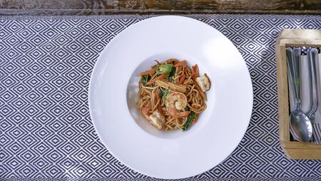 Top view image The spaghetti spicy shrimp in a white plate on the tablecloth.の写真素材