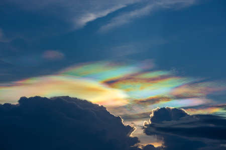 The beauty of the rainbow clouds Above the black clouds in the evening.の写真素材