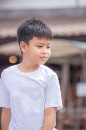 Portrait of Asian boy wearing white  shirt is smile Blurry background.の写真素材
