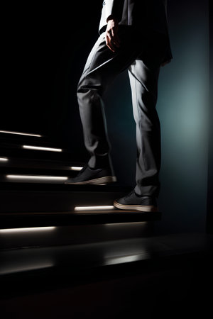 Businessman standing on stairs over dark background. 3D Renderingの素材