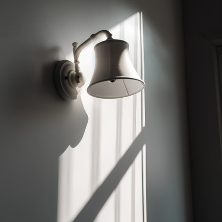 Lamp hanging on the wall in a room with a shadow from the windowの素材