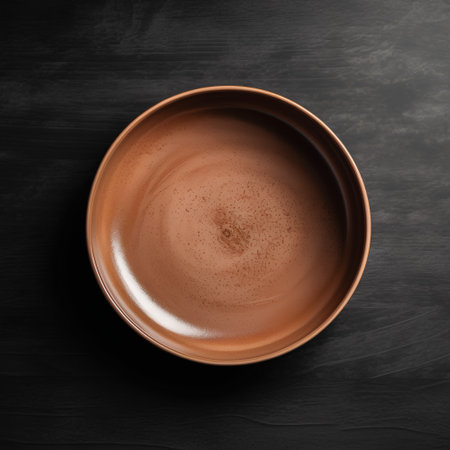 Empty ceramic bowl on black background. Top view with copy space.の素材