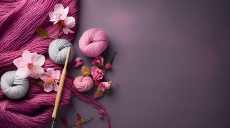 Woolen yarn, knitting needles and flowers on a pink backgroundの素材