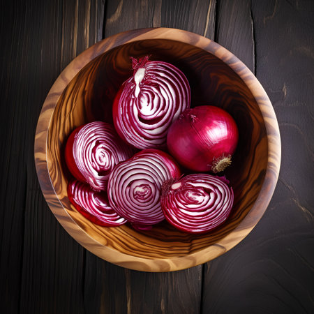 Red onion in wooden bowl on dark wooden background. Top view.の素材