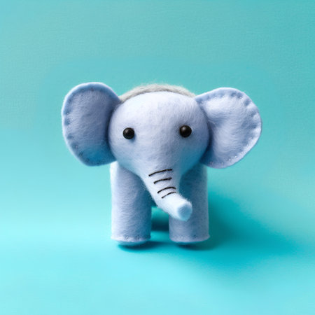 Cute handmade felt elephant on blue background. Minimal creative conceptの素材