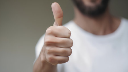 Young man showing thumbs up sign, closeup. Success concept.の素材