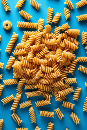 Variety of types and shapes of Italian pasta on blue background.の素材