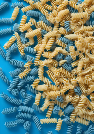 Variety of types and shapes of Italian pasta on a blue backgroundの素材