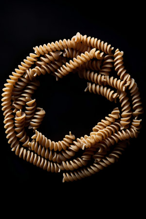 Fusilli pasta isolated on black background. Top view. Flat lay.の素材