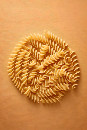 Fusilli pasta on a yellow background. Flat lay, top view.の素材