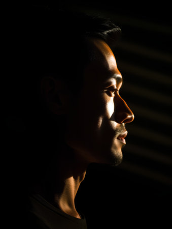 Portrait of a handsome young asian man looking away on black backgroundの素材