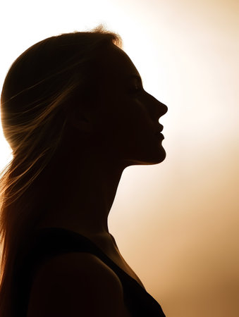 Silhouette of a beautiful woman on a background of the sunの素材