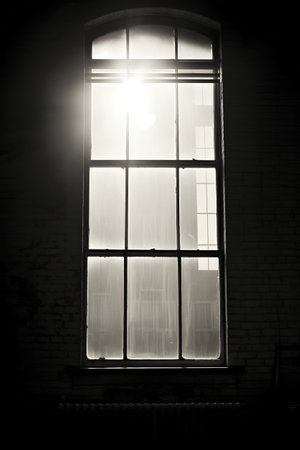 Window in the old house at sunset. Black and white photo.の素材