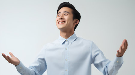 happy asian young businessman in blue shirt, isolated on grey backgroundの素材