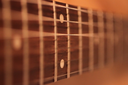 Selective focus shot of frets on a guitarの写真素材