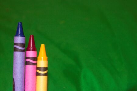 Primary Colored Crayons against Green Backgroundの写真素材