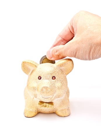 Putting a coin into piggy bankの写真素材