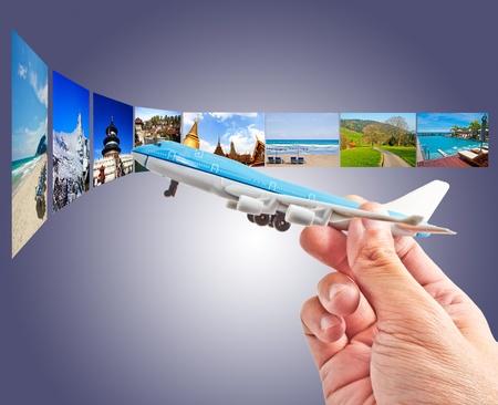 hand holding a model plane with background of many places around the worldの写真素材