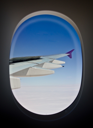airplane s wing from window againt blue skyの写真素材