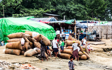 Burmese worker carry sacks of cotton near Irrawadi river, Mandalay, Myanmarのeditorial素材