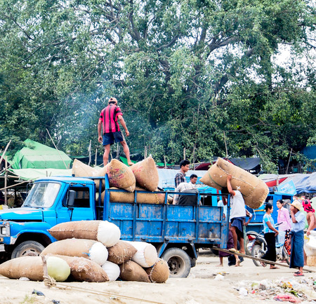 Burmese worker carry sacks of cotton near Irrawadi river, Mandalay, Myanmarのeditorial素材