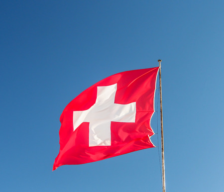 Swiss flag with blue skyの写真素材