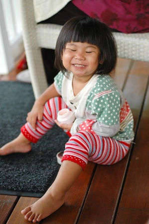 Little asian 2 years old smiling and holding cosmeticの写真素材