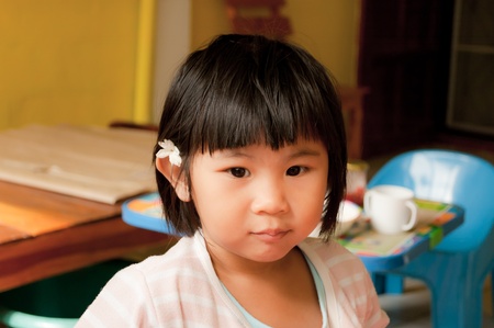 A little girl put jasmin flower on her earの写真素材