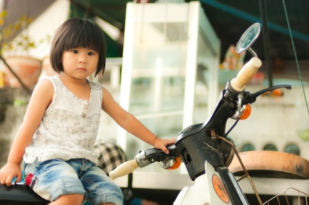 Asian girl sitting on retro motorcycleの写真素材