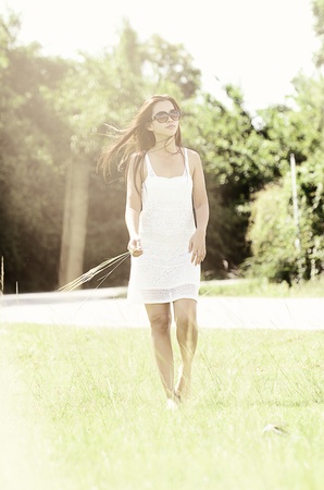 Young Asian Woman walking on green fieldの写真素材