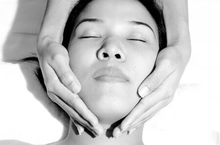 Beautiful young Asian woman receiving facial massageの写真素材