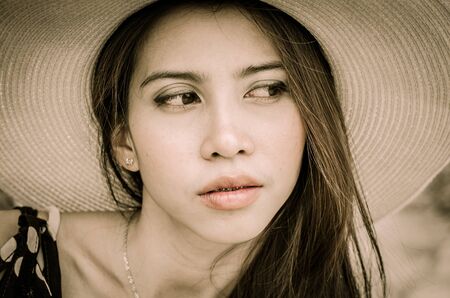 Attractive Asian woman with straw hat processed with vintage syleの写真素材