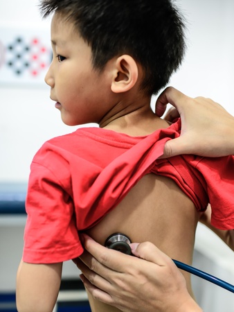 Asian boy at the doctor for a checkup examined with a stethoscopeの写真素材