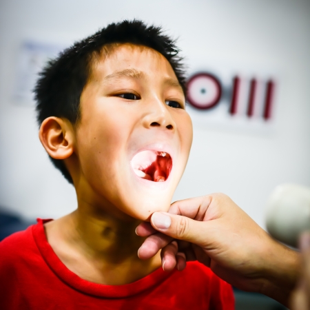 Boy showing his throat to doctorの写真素材