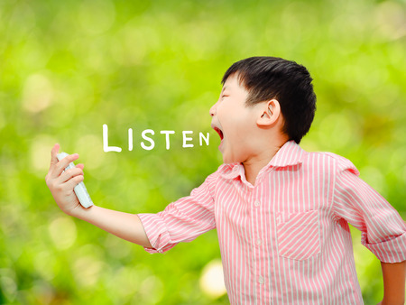 Angry Asian child shouting At Mobile Phone with bokeh backgroundの写真素材