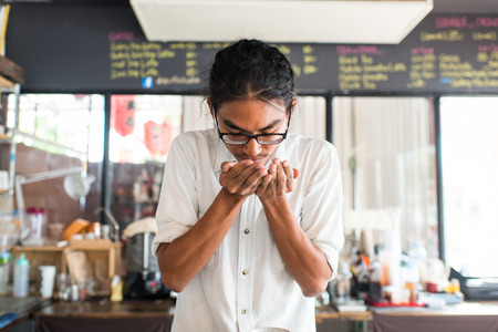 Barista smelling coffee beans in his hand.の写真素材